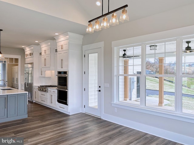 kitchen featuring white cabinets, hanging light fixtures, and sink