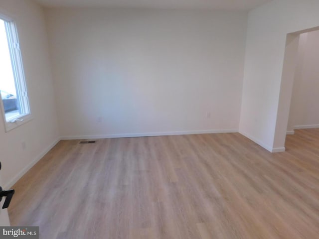 empty room featuring a healthy amount of sunlight and light hardwood / wood-style floors