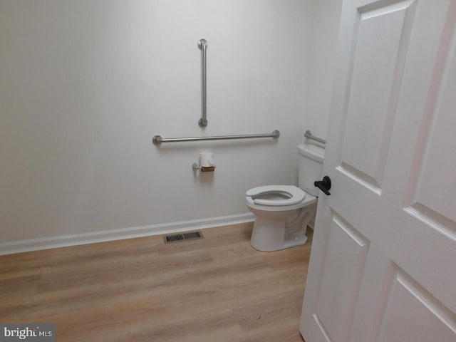 bathroom with toilet and wood-type flooring