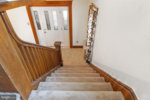 staircase featuring carpet