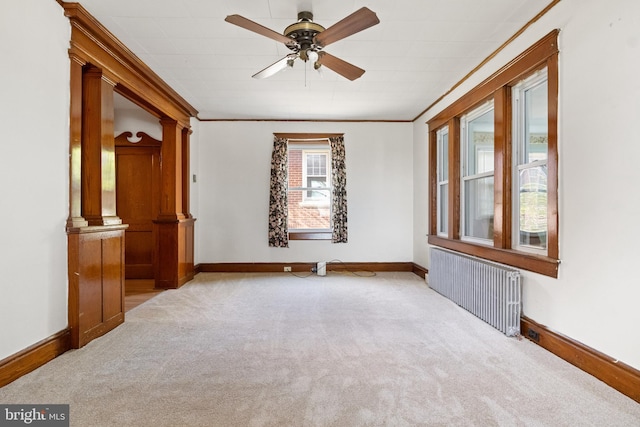 unfurnished room featuring ceiling fan, crown molding, radiator heating unit, and light carpet