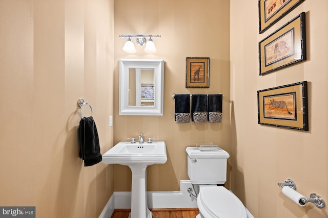 bathroom with hardwood / wood-style flooring, sink, and toilet