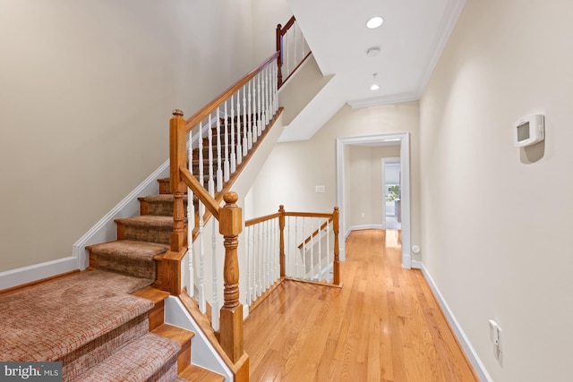 stairs featuring hardwood / wood-style floors and crown molding