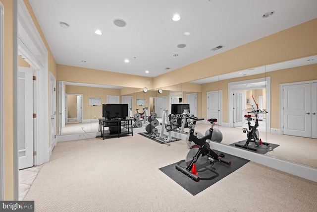 workout room featuring light carpet