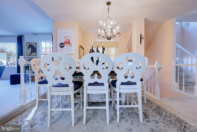 dining area featuring light carpet and an inviting chandelier