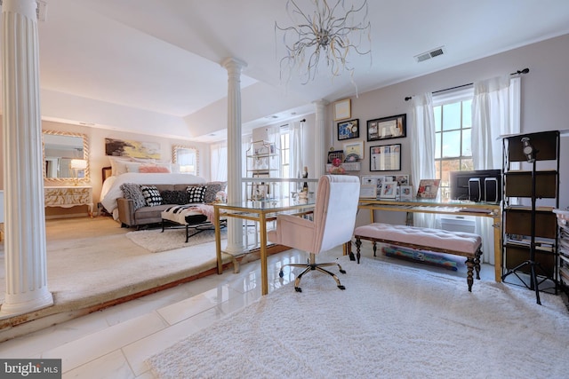 bedroom with decorative columns and a desk