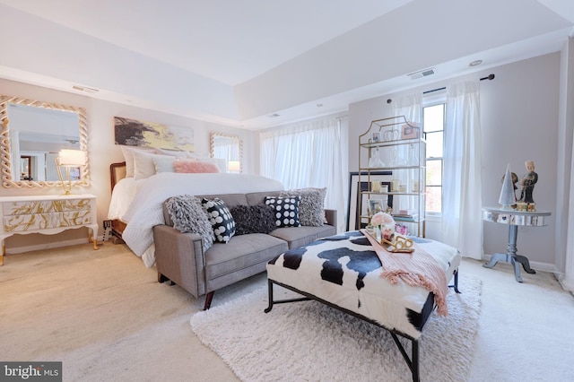 carpeted bedroom featuring baseboards and a raised ceiling
