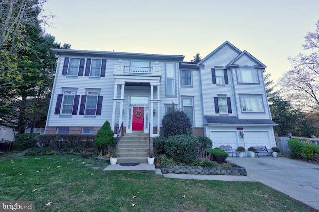 view of front of house featuring concrete driveway, a lawn, and an attached garage