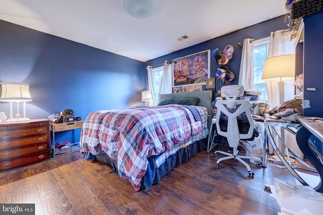 bedroom with dark hardwood / wood-style flooring