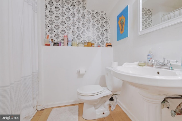 full bath featuring toilet, curtained shower, and wood finished floors