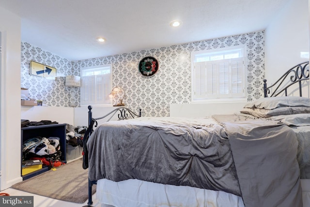 bedroom featuring wallpapered walls, multiple windows, and recessed lighting