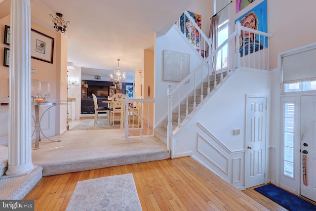 foyer featuring a chandelier, stairs, hardwood / wood-style floors, and a towering ceiling