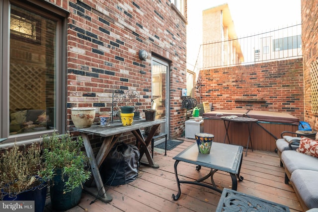 wooden deck featuring an outdoor living space and a hot tub