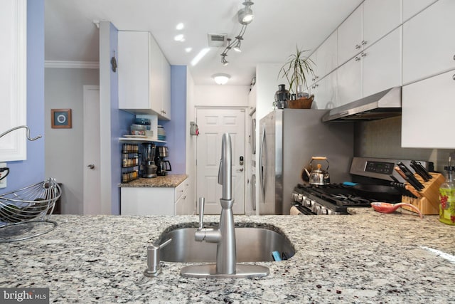 kitchen featuring light stone counters, ornamental molding, gas range, ventilation hood, and white cabinetry