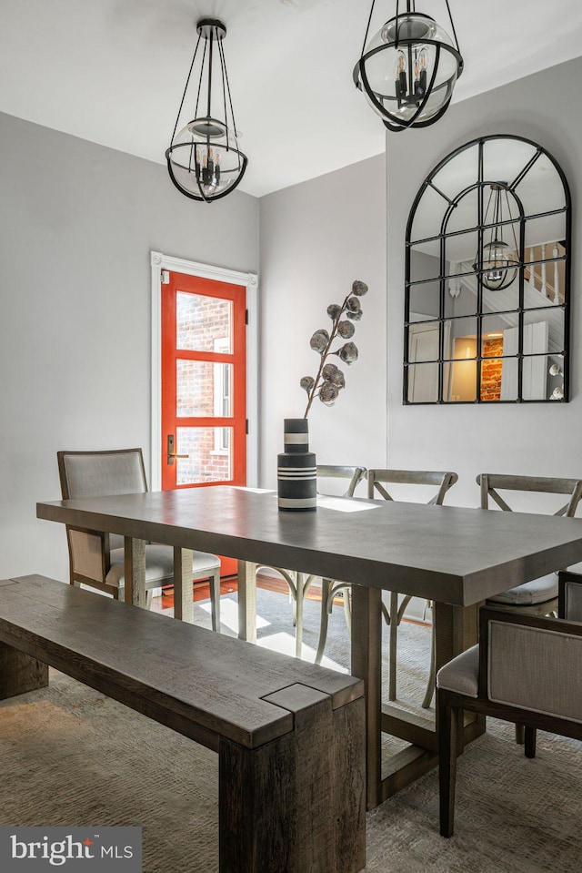 dining area with carpet flooring and a notable chandelier