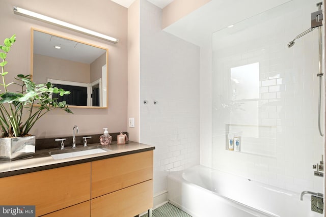 bathroom featuring tile patterned flooring, vanity, and tiled shower / bath