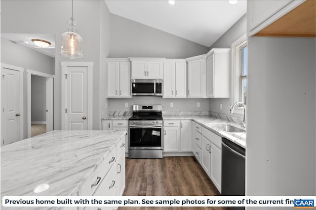 kitchen with sink, white cabinetry, stainless steel appliances, and vaulted ceiling