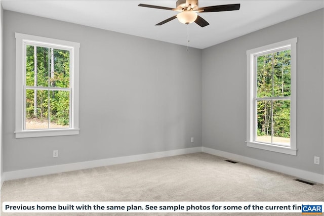 carpeted empty room featuring a wealth of natural light and ceiling fan