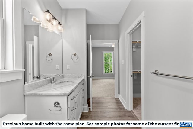 bathroom with ceiling fan, vanity, wood-type flooring, and toilet