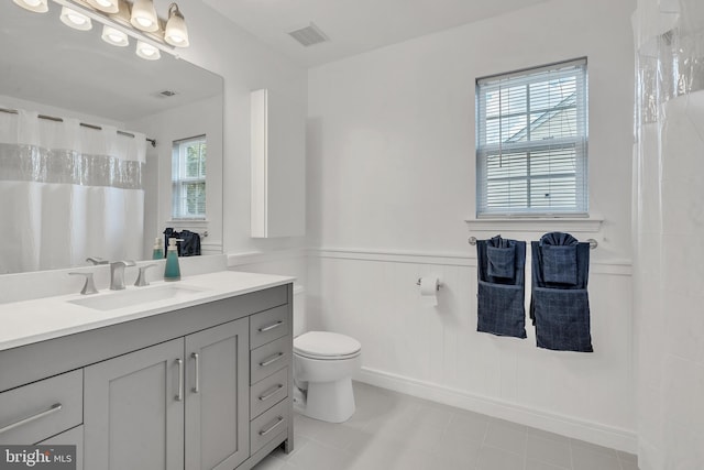 bathroom featuring plenty of natural light, toilet, and vanity