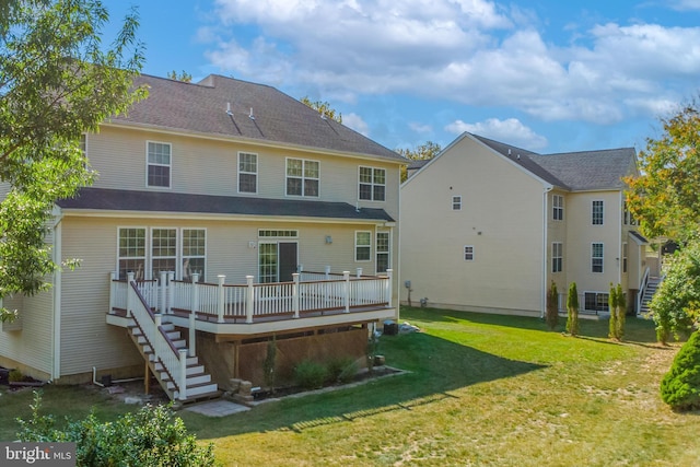 rear view of property featuring a wooden deck and a yard