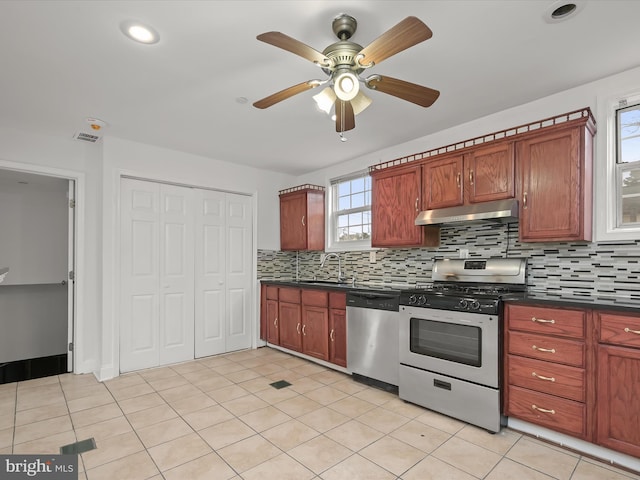 kitchen with tasteful backsplash, appliances with stainless steel finishes, light tile patterned flooring, and sink