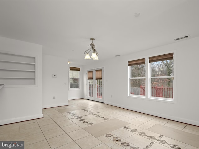 unfurnished living room featuring plenty of natural light, built in features, french doors, and light tile patterned flooring