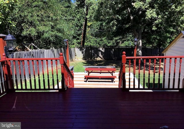 wooden deck featuring a lawn