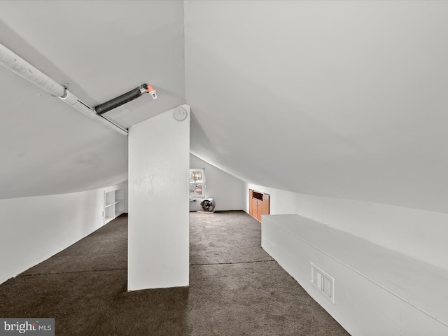 bonus room featuring vaulted ceiling and dark carpet