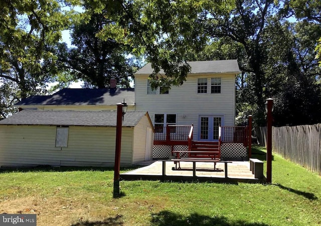 back of property with a wooden deck, a lawn, and french doors