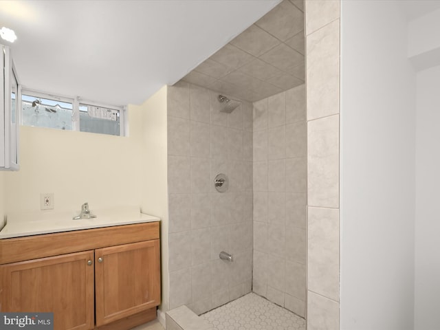 bathroom with tiled shower and vanity