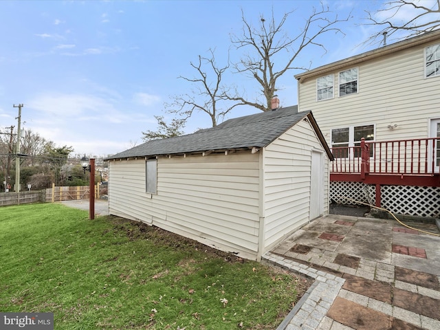 view of property exterior featuring an outbuilding, a yard, a deck, and a patio area