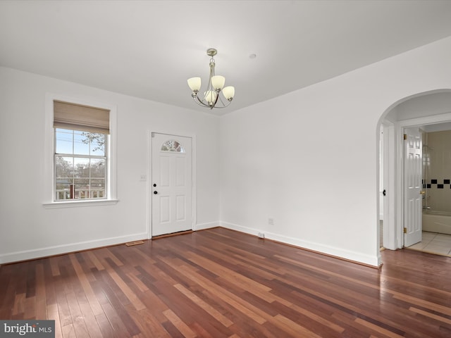 spare room featuring dark hardwood / wood-style floors and a notable chandelier