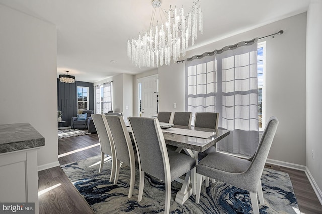 dining space featuring dark hardwood / wood-style floors and a chandelier