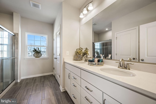 bathroom featuring vanity and a shower with shower door