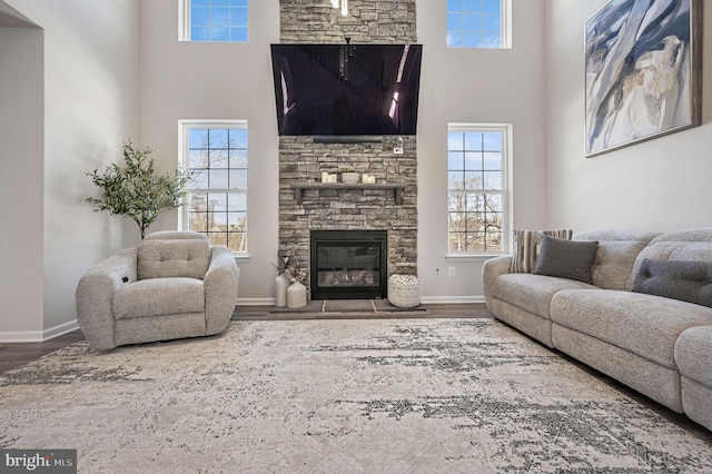 living room featuring a towering ceiling, hardwood / wood-style floors, and a fireplace