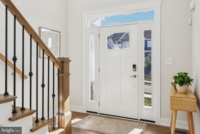 entryway with dark hardwood / wood-style flooring