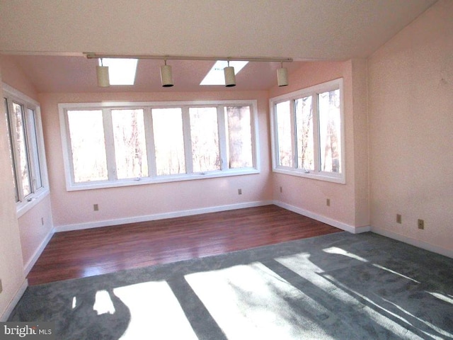 spare room featuring dark hardwood / wood-style flooring and vaulted ceiling