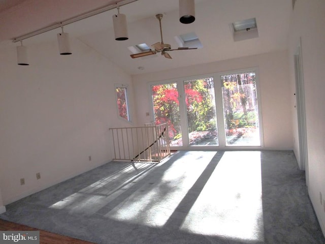 carpeted empty room with high vaulted ceiling and ceiling fan