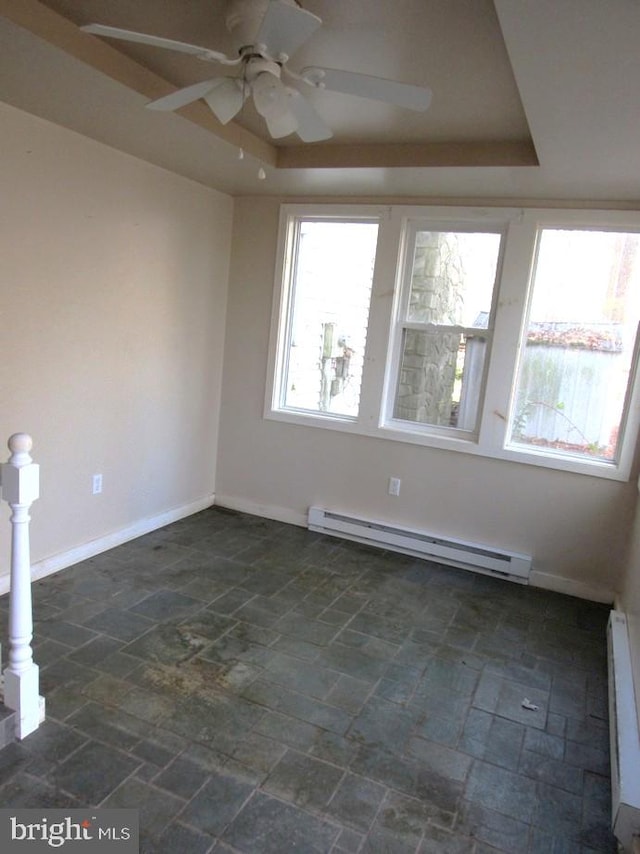 spare room with ceiling fan, a raised ceiling, and a baseboard radiator