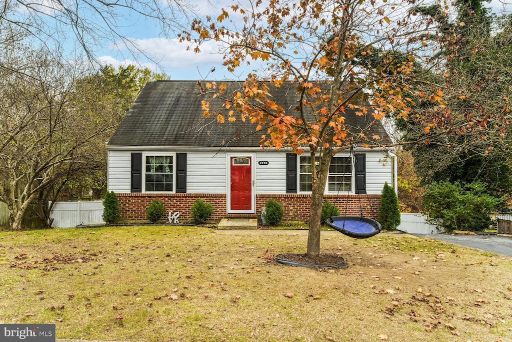 cape cod house with a front yard