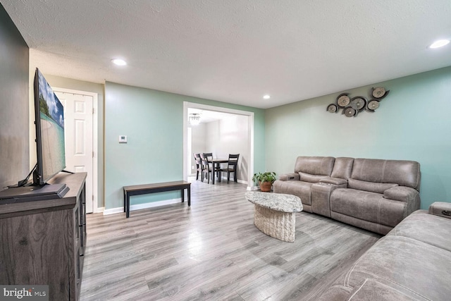 living room with a textured ceiling and light wood-type flooring