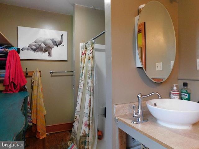 bathroom with a shower with shower curtain, hardwood / wood-style flooring, and sink