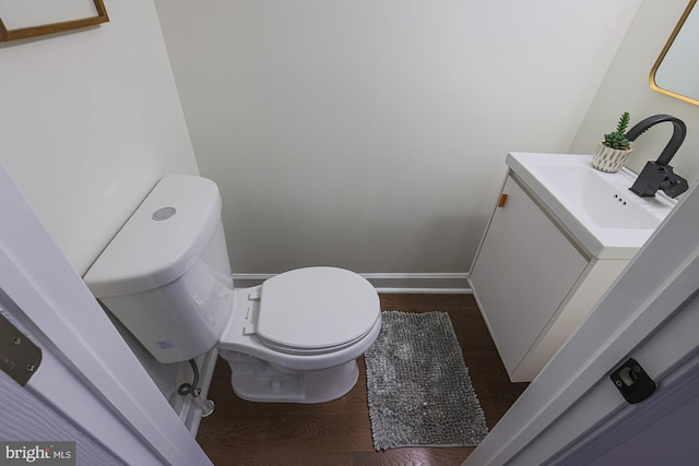 bathroom featuring vanity, hardwood / wood-style flooring, and toilet