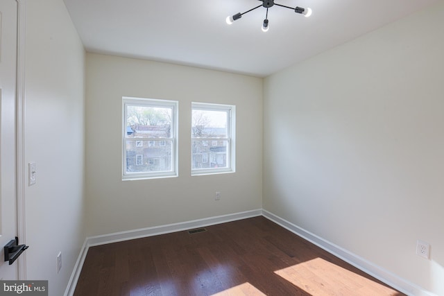 spare room featuring dark wood-type flooring