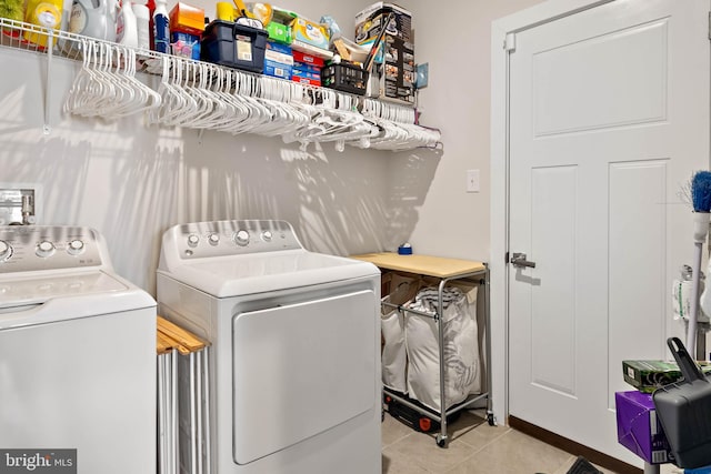 laundry area with washer and dryer and light tile patterned flooring