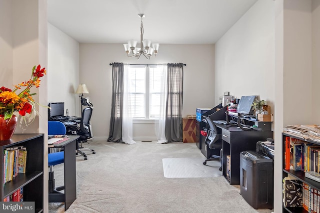 carpeted home office featuring a chandelier