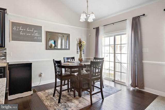 dining space featuring lofted ceiling, dark hardwood / wood-style floors, and an inviting chandelier