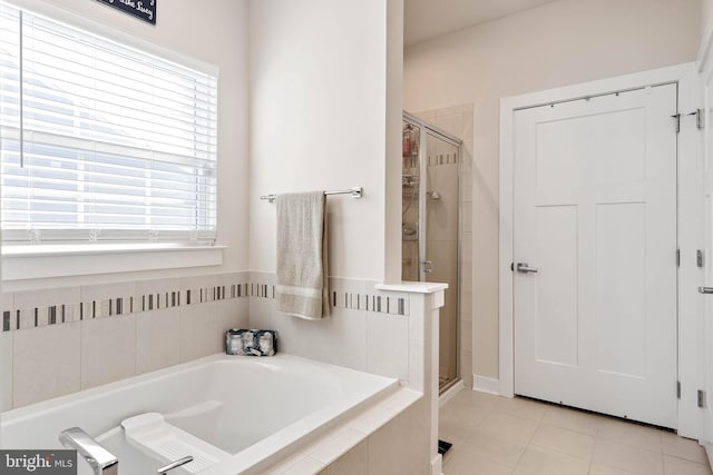 bathroom featuring tile patterned flooring, separate shower and tub, and a wealth of natural light