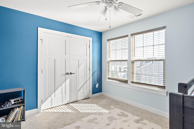 interior space with ceiling fan and light colored carpet